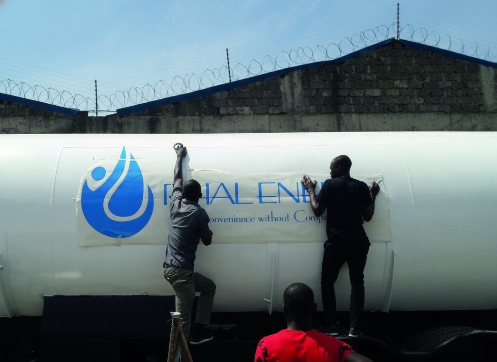 Cut vinyl being squeegeed onto a tanker on site